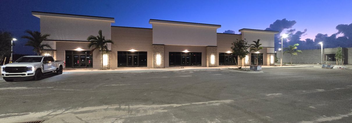 Commercial building exterior at dusk with new exterior lighting installed by H3 Industries in Palm Beach Gardens