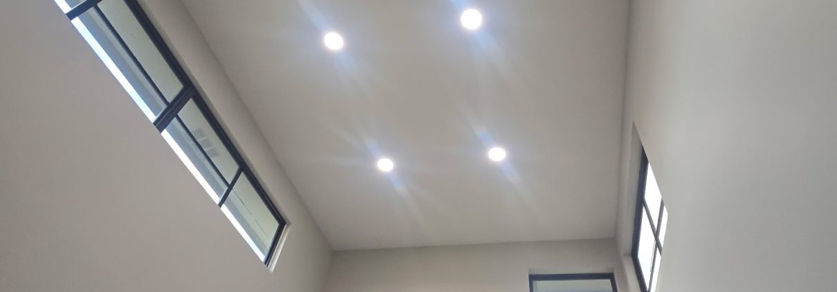 Recessed LED lights installed in a tall vaulted ceiling by H3 Industries in Palm Beach Gardens