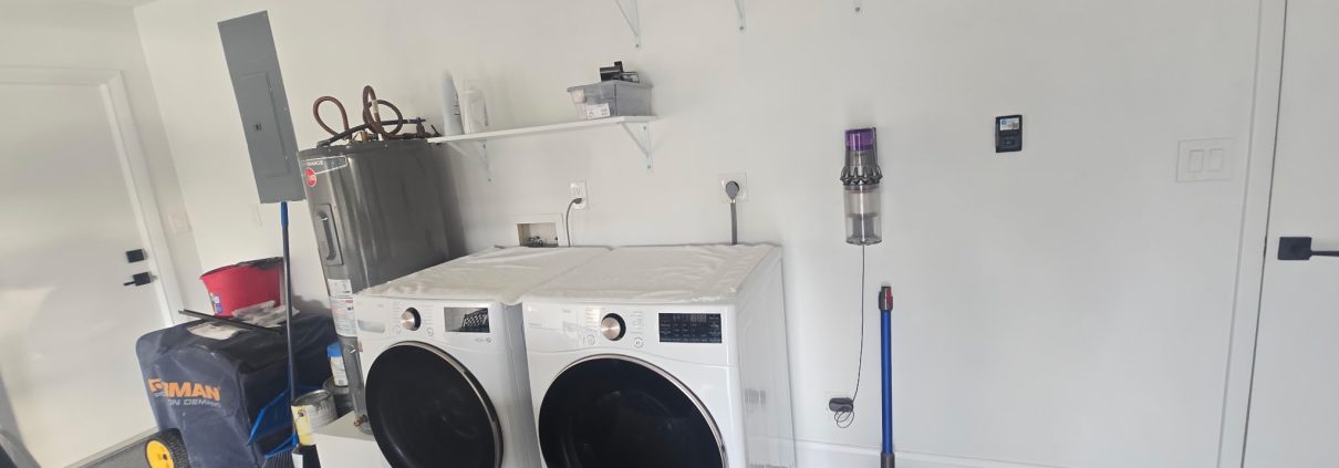 Laundry room with front-load washer and dryer, wall shelving and a hanging rod installed by H3 Industries in Palm Beach Gardens