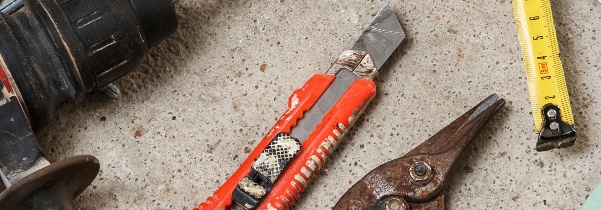 Drywall tools and metal framing materials, including a drill, tin snips, tape measure and level, for plasterboard wall work by H3 Industries in Palm Beach Gardens